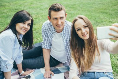 Grup arkadaşıyla parkta güneşli bir günde bir selfie alarak. Dostluk, yaşam tarzı, rekreasyon kavramı