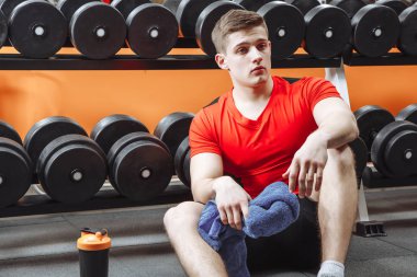 Spor salonunda bir çalışmadan sonra dinlenme genç çekici adam.