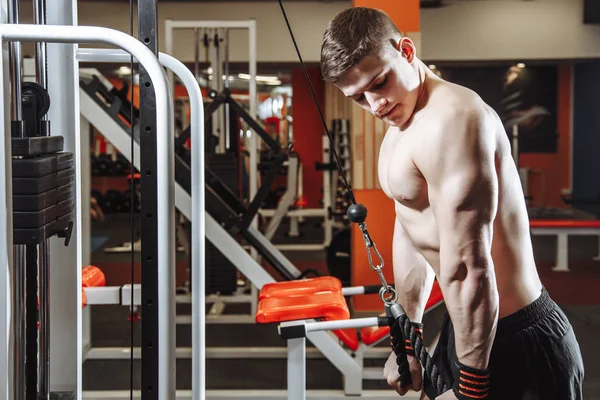 Spor salonunda pazı egzersizleri yaparken yakışıklı delikanlı. Fitness, spor ve sağlıklı yaşam kavramı.