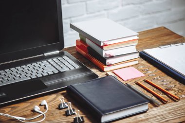 Öğrenci, Sekreter ofiste, Yöneticisi çalışma alanı. Dizüstü bilgisayar, kitap, kulaklık, dizüstü bilgisayar ve Kırtasiye ahşap bir masa üzerinde