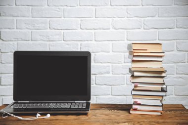 İşyeri dizüstü bilgisayar, kitap ve kulaklıklar
