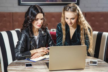 Ekip çalışması. İki tablo ve çalışma ofisinde oturan genç iş kadın gülümsüyor. Online öğrenme, chat yapan öğrenciler. Beyin fırtınası