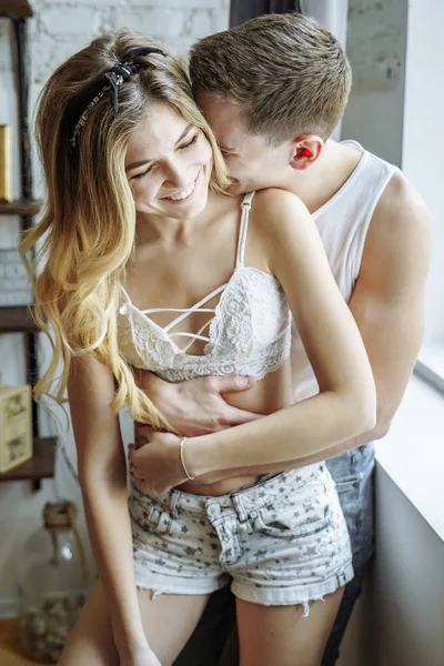 Momenti felici insieme. Felice giovane coppia che abbraccia e sorride a casa . — Foto Stock