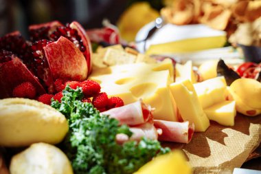Aperatifler, peynir, jamon, taze meyve ve çilek lezzetli ürün yelpazesine.