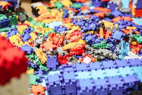 A lot of small colorful parts of children's designer on the table or floor — Stock Photo, Image