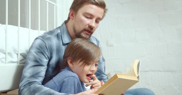 Pai Pai Carinhoso Está Lendo Livro Interessante Para Seu Filho — Vídeo de Stock