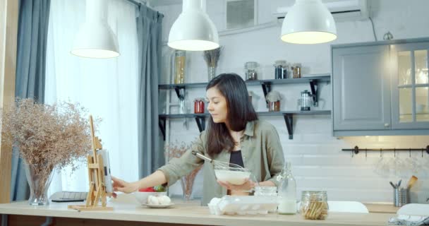 Młoda Atrakcyjna Kobieta Przygotowująca Ciasto Naleśniki Lub Ciasteczka Pomocą Tabletu — Wideo stockowe