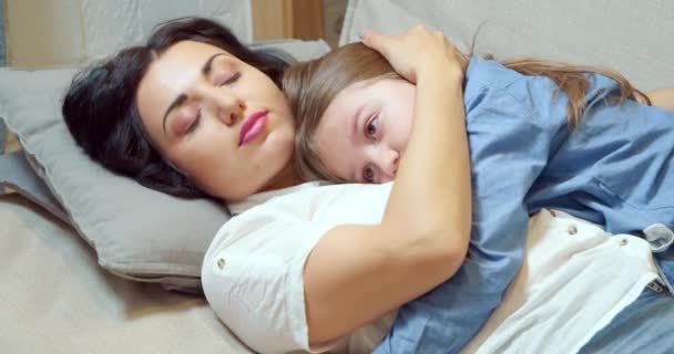 Догляд Матір Обіймає Пестить Свою Маленьку Дочку Лежить Дивані Вдома — стокове відео