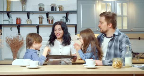 부엌에 어린이들이 기뻐하며 박수치는 쿠키와 접시를 나르고 어머니 — 비디오