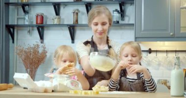 Mutlu aile kurabiye için hamur hazırlıyor. Mutfakta annene yardım eden iki tatlı kız..