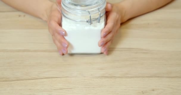 テーブルの上に白い小麦粉のボウルを置く女性の手の閉じる — ストック動画