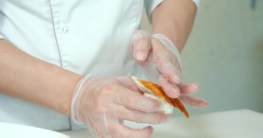 Yakından erkek eli suşi eldivenle pişirir mutfakta taze sashimi pilav ve ton balığı pişirir.