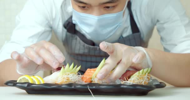 Close Asiatisk Mand Sushi Kok Iført Maske Handsker Tjener Sashimi – Stock-video