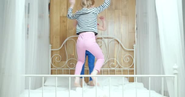 Две Забавные Маленькие Девочки Смеются Прыгают Кровати Веселясь Вместе Дома — стоковое видео