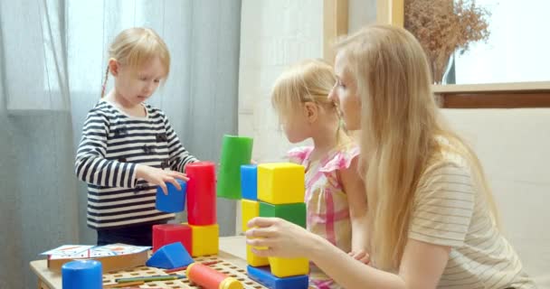 Jovem Mãe Duas Filhas Bonitos Brincando Com Blocos Plástico Coloridos — Vídeo de Stock