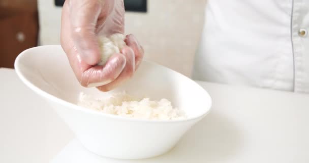 米を取り 寿司ロールの基礎を準備する手袋で男性の料理人の手を閉じます 寿司の調理法 — ストック動画