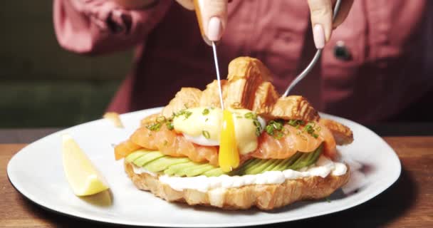 Close Mãos Femininas Cortando Delicioso Croissant Com Queijo Abacate Fatias — Vídeo de Stock