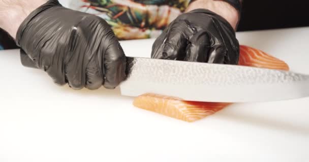特写男性厨师手戴手套切鲑鱼片 白板上有刀 — 图库视频影像