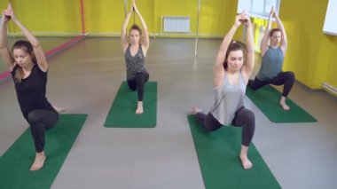 Yoga sınıfındaki eğitmenle esneme dersleri alan bir grup sağlıklı genç kadın..