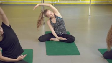 Yoga sınıfındaki eğitmenle esneme dersleri alan bir grup sağlıklı genç kadın..