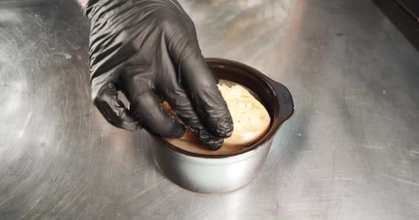 男厨师手拿着手套 在厨房里用脆面包和奶酪皮煮洋葱汤 — 图库视频影像