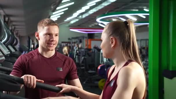 Νεαρός Άντρας Και Κορίτσι Μιλάνε Και Χαμογελούν Στο Γυμναστήριο — Αρχείο Βίντεο
