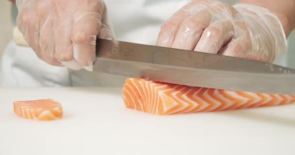 Männliche Kochhände Großaufnahme Handschuhen Schneiden Lachsfilet Mit Messer Auf Weißem — Stockvideo