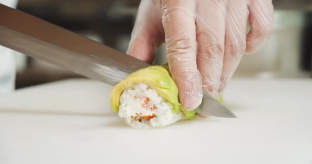 Erkek Aşçıların Eldiven Giyip Mutfakta Avokadoyla Lezzetli Suşi Sarmaları Hazırlamalarını — Stok video