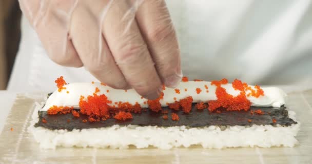 男厨师手拿着手套在厨房里准备美味的寿司卷 里面放着软软奶酪和烤面包 — 图库视频影像