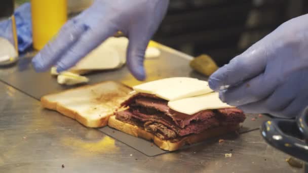 Primer Plano Delicioso Sándwich Con Pastrami Pepinillos Queso Sobre Mesa — Vídeos de Stock