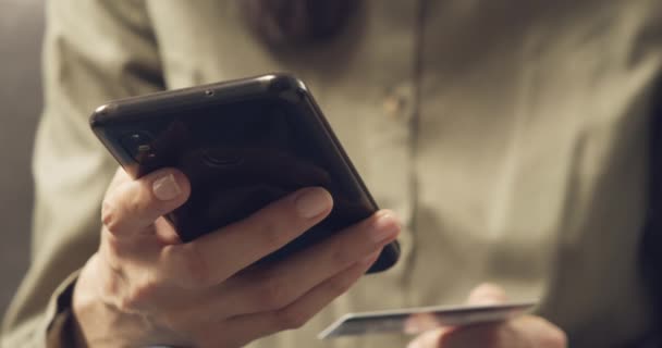 自宅でオンラインショッピングをしながら スマートフォンやクレジットカードを持っている女性の手の閉鎖 オンラインショッピング ライフスタイルの概念 — ストック動画