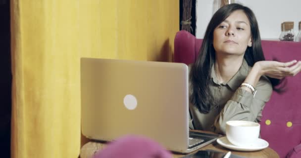 Εστιασμένη Νεαρή Γυναίκα Που Χρησιμοποιεί Φορητό Υπολογιστή Και Πίνει Καφέ — Αρχείο Βίντεο