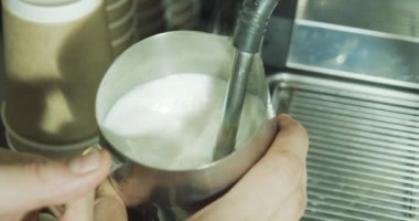 Kahve yapma sürecini kapat. Kahve dükkanında kapuçino için süt sallayan profesyonel bir barista..