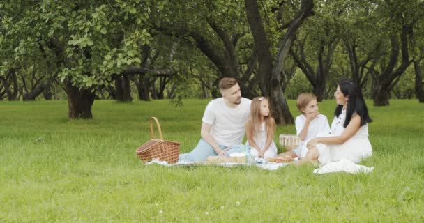 Šťastná Rodina Dětmi Odpočívající Trávě Během Pikniku Malebné Zelené Zahradě — Stock video