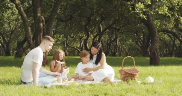 Familia Feliz Con Niños Descansando Hierba Durante Picnic Pintoresco Jardín — Vídeo de stock