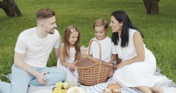 Família Feliz Com Crianças Relaxando Grama Divertindo Juntos Durante Piquenique — Vídeo de Stock