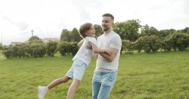 Feliz Padre Recogiendo Desenrollando Niño Parque Papá Hijo Jugando Césped — Vídeos de Stock