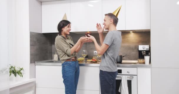 Joven Pareja Feliz Gorras Soplando Una Vela Cupcake Cumpleaños Celebrando — Vídeo de stock