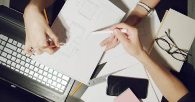 Proje çizimlerini tartışan ve dizüstü bilgisayar üzerinde çalışan mühendislerin ya da tasarımcıların iş yerlerini kapatın.