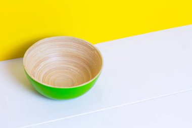 Bambu yeşil plaka üzerinde beyaz ahşap masa, sarı renk Kağıt arka plan, kağıt deseni, yan görünüm
