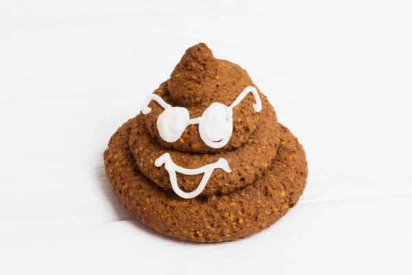 Funny poop emoji chocolate cupcakes with white decor and glasses. Cute food dessert. Free place for text. Copyspace