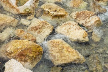 Sualtı deniz taşları, dalgaların ve dalgalar, güzel desen şeffaf temiz su ile yüzey