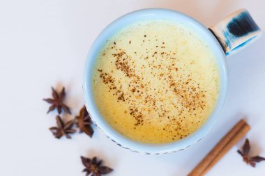 Zerdeçal latte boşaltmak ile beyaz ahşap masa üzerinde görüntüsünü üstten görünüm