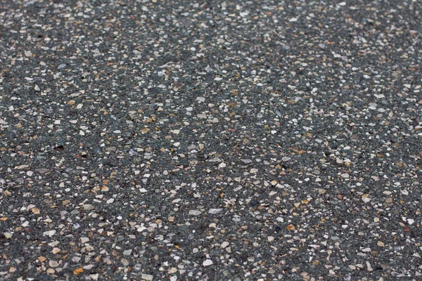 Düz koyu gri asfalt kaplama doku küçük kayalar ile