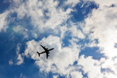 Uçak beyaz bulutlar, arka plan mavi gökyüzü.