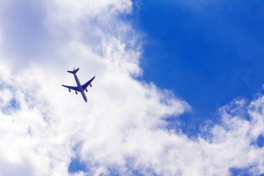 Uçak beyaz bulutlar, arka plan mavi gökyüzü.