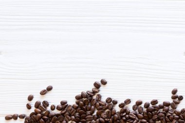birden fazla kavrulmuş kahve çekirdekleri beyaz yapısal ahşap zemin, düz üzerinde yatıyordu.