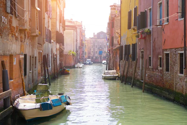 Beautiful Venice canal in early morning light. Old narrow canal with parked boats, Venice, Italy. Picturesque cityscape of Venice, Italy, Europe. Traveling concept background.