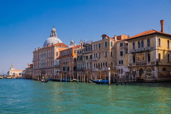 Güzel renkli görüntü moorings ve ön planda ve eski bir gondol Venedik bir kanal içinde belgili tanımlık geçmiş mavi bulutlu gökyüzü altında evler.