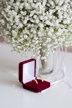 Alyans içinde kırmızı kadife kutu ve üzerinde beyaz bir tablo - seçici odak, Gelin Buketi kopyalama alanı, dikey yönlendirme